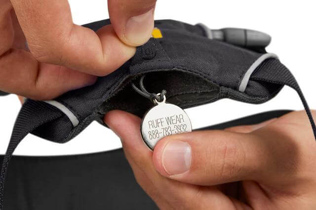 Person adjusting the Ruffwear Front Range everyday padded dog harness with identification tag.