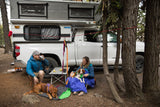 Campers enjoying time with dogs using the Ruffwear Dog Tether for a campsite dog-hitching system.